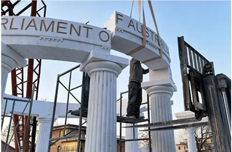 Installing a contemporary marble sculpture using a crane at the project site