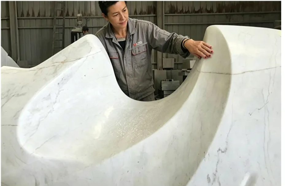 Craftsman inspecting a contemporary marble sculpture during the early production stage